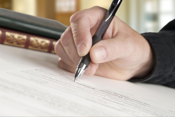 A man writing with pen on surface